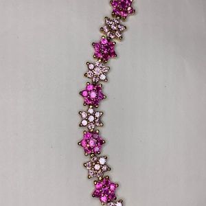 Pink gem and gold tone bracelet.